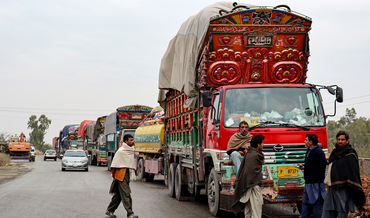 Truck drivers gather beside aid supply trucks, parked along a roadside in Hangu on January 4, 2025. (AFP/ file)