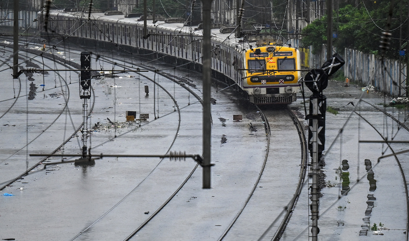 A local train rides through a flooded railway track during heavy rain showers in Mumbai on August 18, 2025. (AFP/ file)