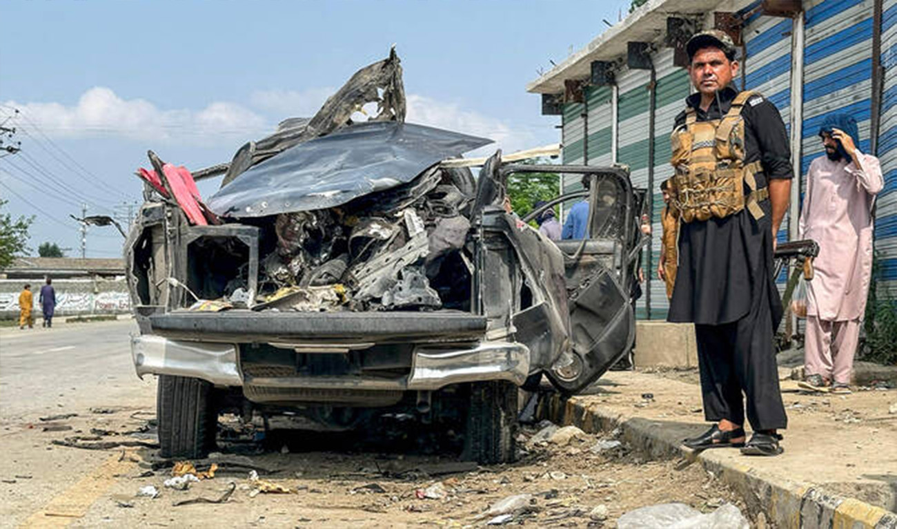 A security personnel stands guard beside the wreckage of a vehicle after a blast in Bajaur district of Khyber Pakhtunkhwa province, Pakistan, on July 2, 2025. (AFP/File)