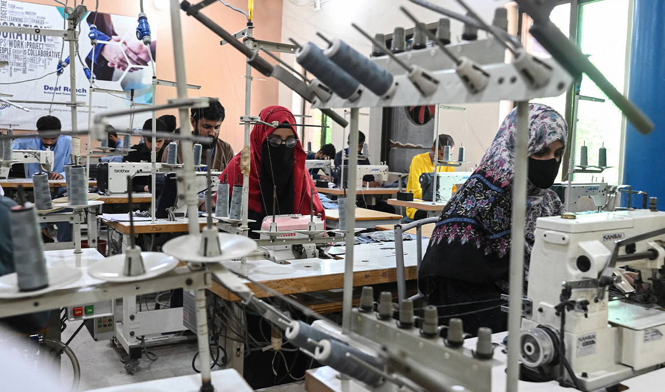 This photograph taken on May 6, 2024 shows hearing-impaired youths operating sewing machines in a vocational training centre at a school run by the charity Deaf Reach, a non-profit organisation working to empower disadvantaged deaf children and youths, in Lahore. (AFP/File)