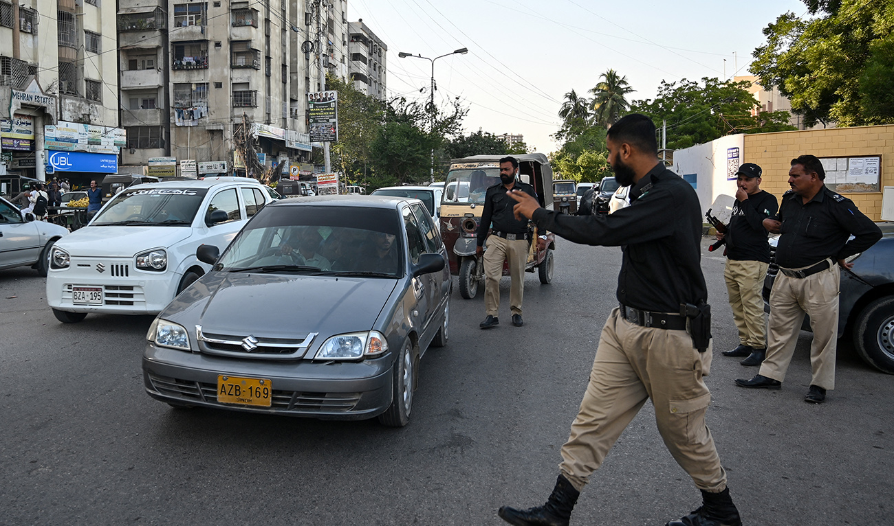 A policeman stops vehicles for searches along a road in Karachi on November 12, 2025