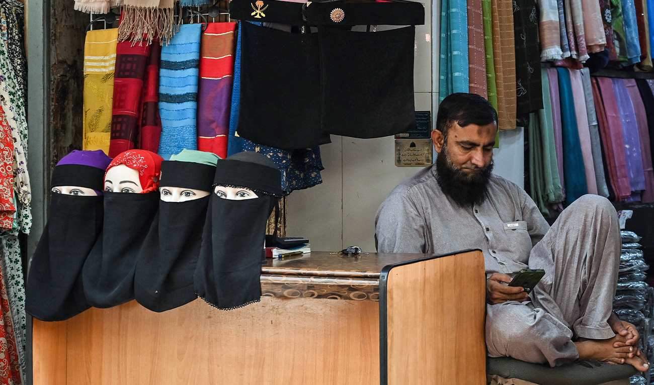 A shopkeeper waits for customers at a cloth market in Karachi, Pakistan, on November 24, 2025. (AFP/File)