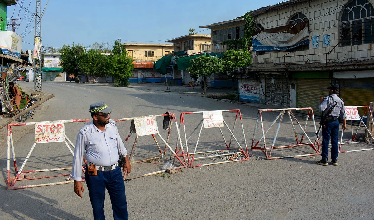 Policemen stand guard along a barricaded street near an army cantonment, a day after it was attacked by a militant suicide squad in Bannu on July 16, 2024. (AFP/File)
