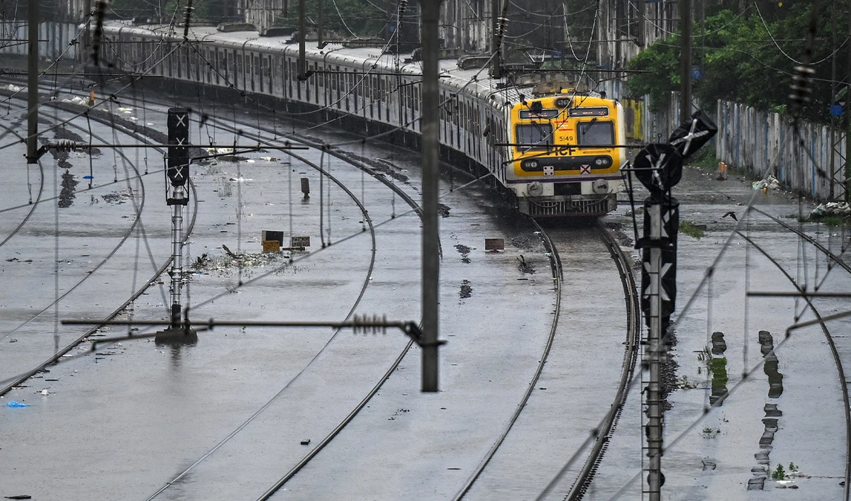 A local train rides through a flooded railway track during heavy rain showers in Mumbai on August 18, 2025. (AFP/ file)