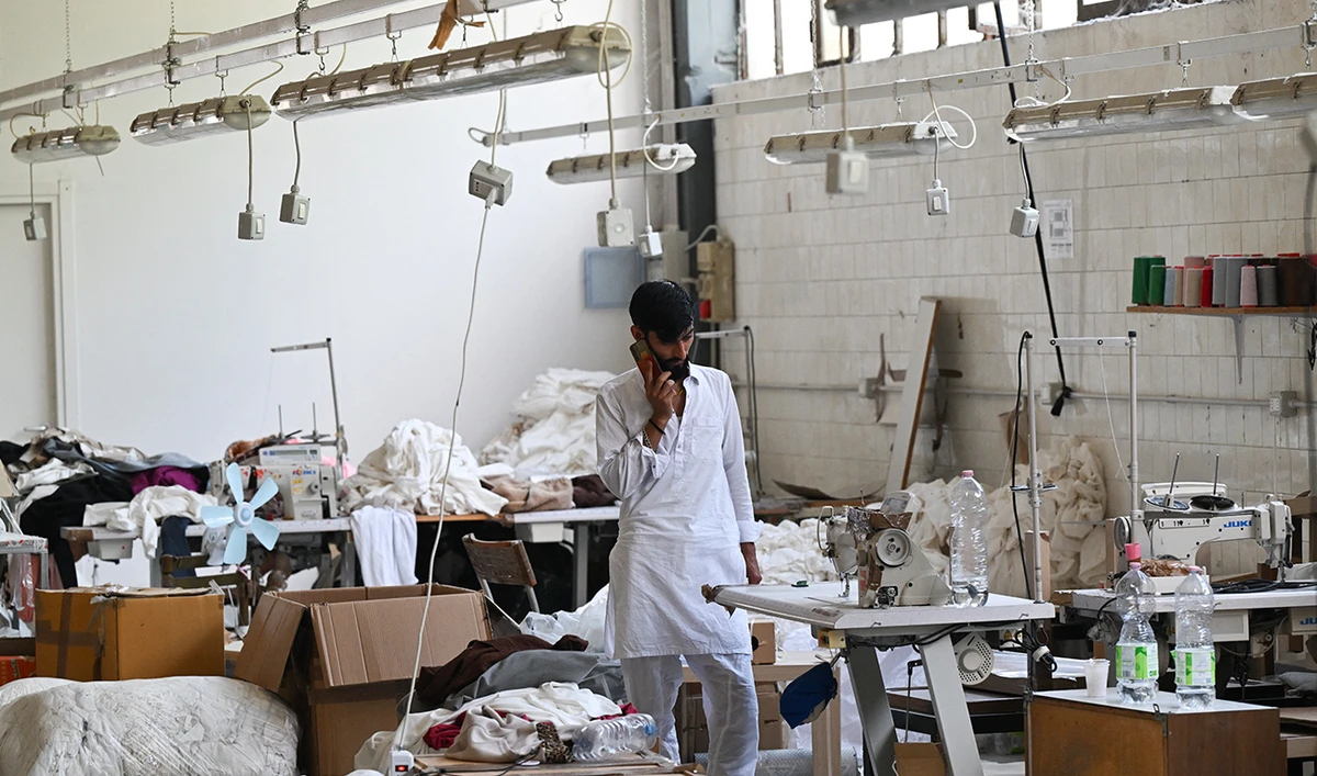A Pakistani worker gives a phone call during a permanent strike in a fast-fashion outlet factory owned by a Chinese company in Prato, central Italy, on August 1, 2025. (AFP/ file)