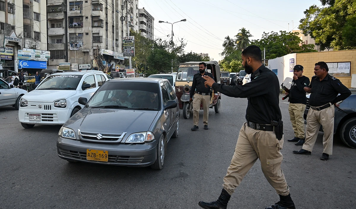 A policeman stops vehicles for searches along a road in Karachi on November 12, 2025