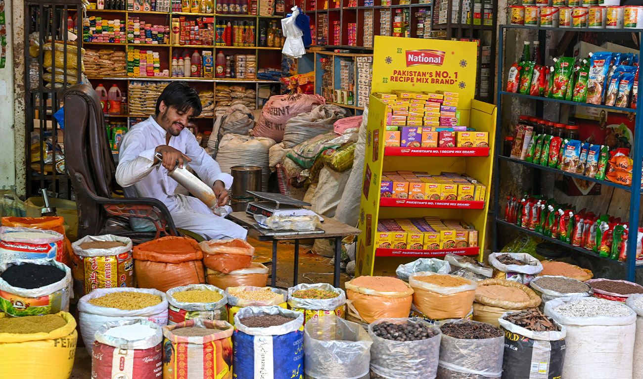 A shopkeeper sells spices at a market in Lahore on June 10, 2025. (AFP/File)