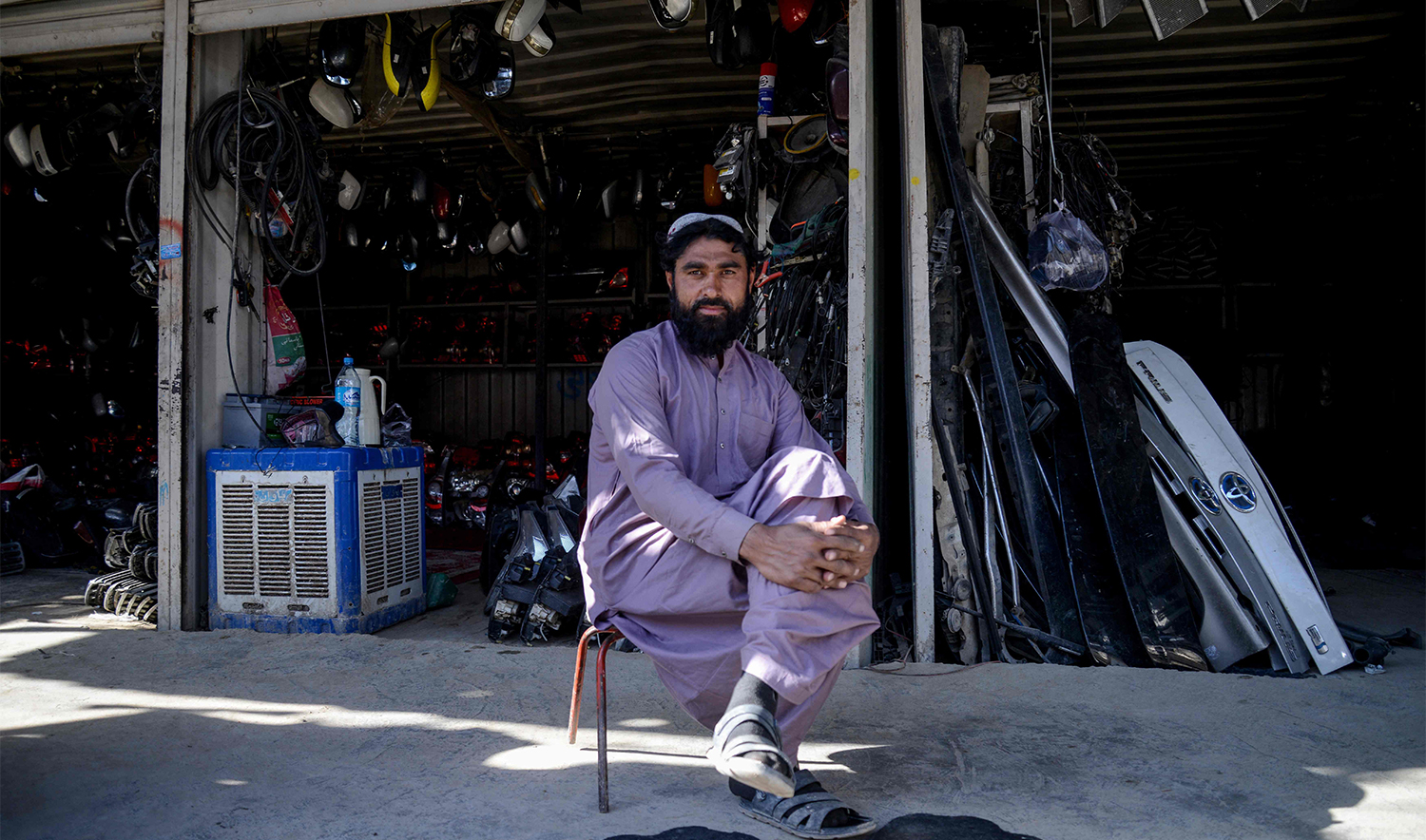 This photograph taken on December 29, 2025 shows a man sitting outside an auto parts shop at a market near the zero-point border crossing between Afghanistan and Pakistan in the Spin Boldak district of Kandahar province. (AFP)