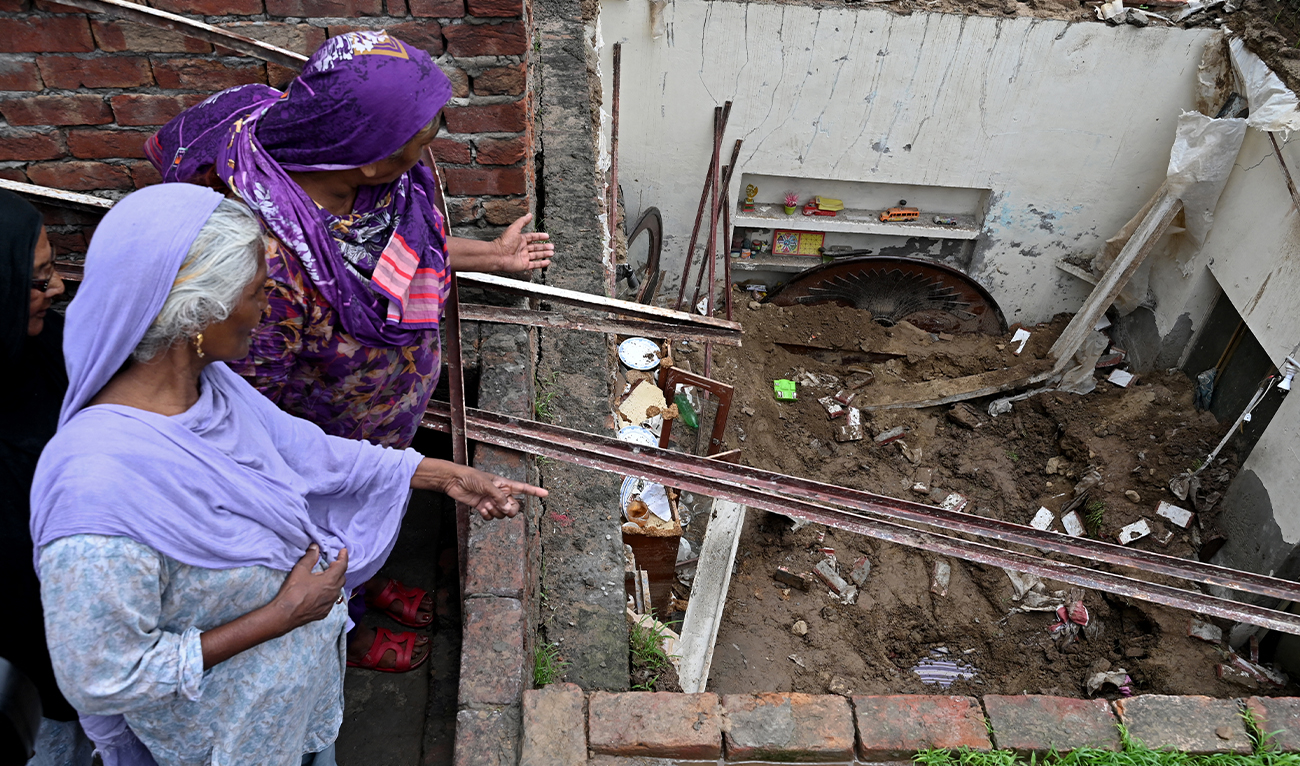 Neighbours look at the collapsed roof of a house owing to heavy monsoon rains in Lahore on July 16, 2025. (AFP/ file)