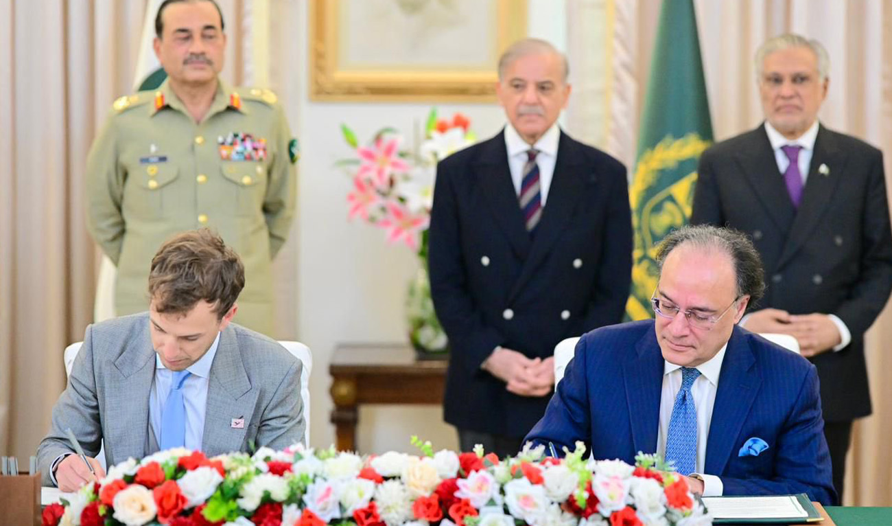 Finance Minister of Pakistan, Muhammad Aurangzeb (front-right) signing an MoU with a representative of the World Liberty Financial in Islamabad on January 14, 2026. (@PakistanVARA/X)