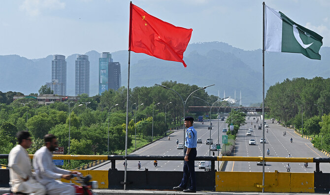 A policeman stands guard under the national flags of China and Pakistan along a road ahead of the visit of Chinese Vice Premier He Lifeng, in Islamabad on July 30, 2023. (AFP/File)