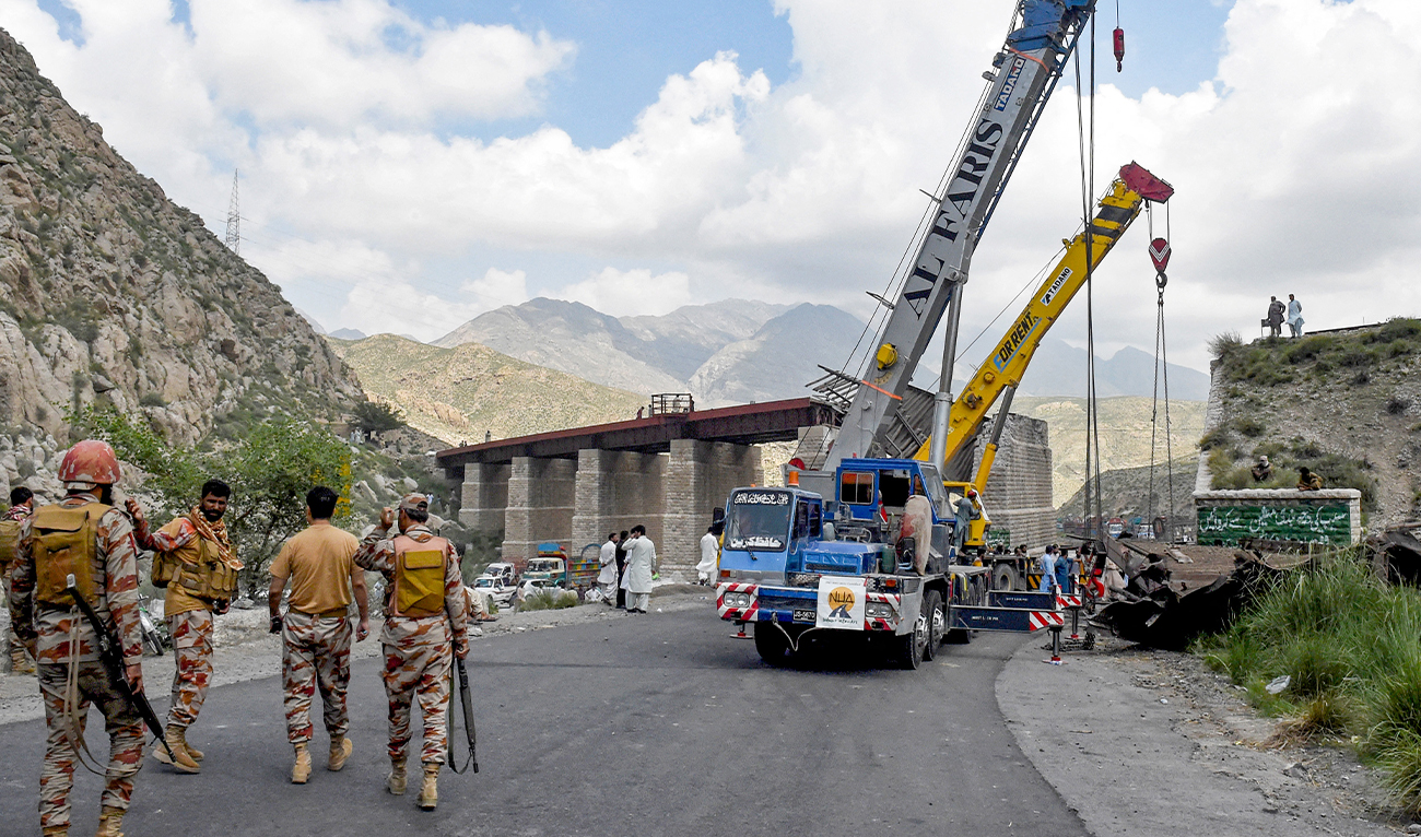 Pakistan's paramilitary rangers walk past cranes clearing the wreckage of a collapsed railway bridge a day after a blast by separatist militants at Kolpur in Bolan district, Balochistan province on August 27, 2024. (AFP/ file)