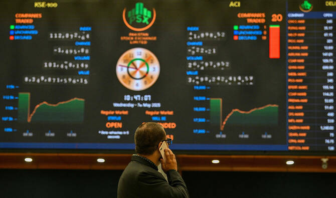 A stockbroker monitors share prices on a digital screen at the Pakistan Stock Exchange (PSX) in Karachi on May 7, 2025. (AFP/File)