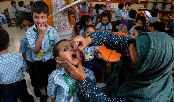 A health worker administers a polio vaccine to a child in a school, in Karachi, Pakistan, on Sept. 1, 2025. (AP/File)