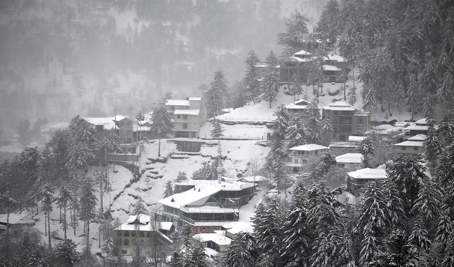 Commuters drive through a snow-covered street in Murree on January 23, 2026. (AFP/File)