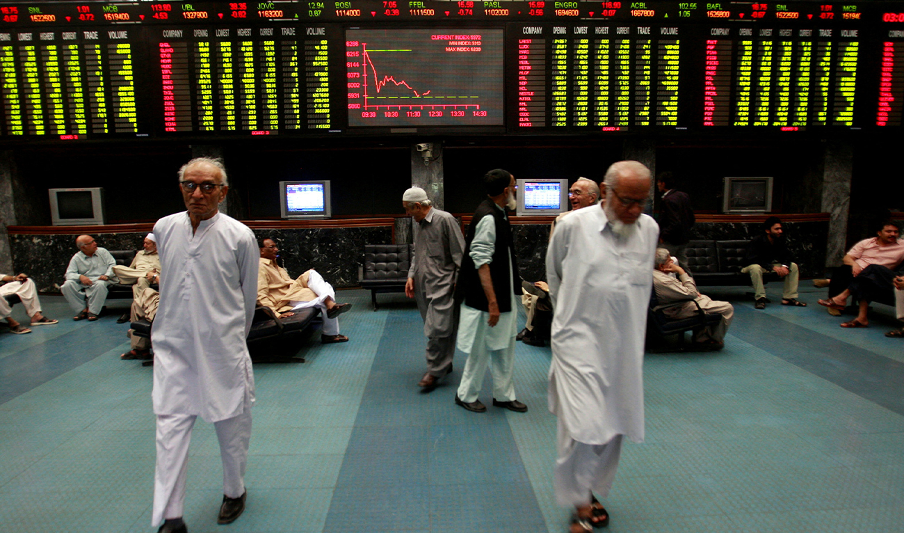 Stockbrokers walk under the digital board during a trading session inside the trading hall of the Karachi Stock Exchange, January 12, 2009. (REUTERS)