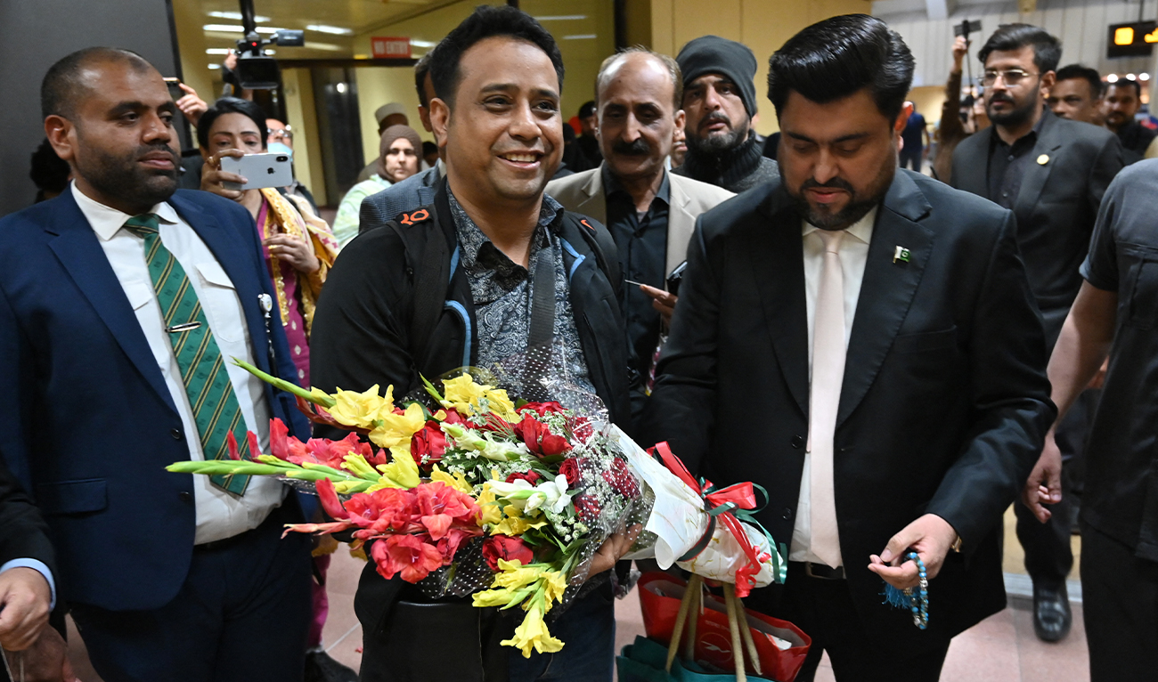 Governor Sindh Kamran Khan Tessori (R) welcomes a passenger from Dhaka arriving at Jinnah International Airport in Karachi on January 30, 2026. (AFP)