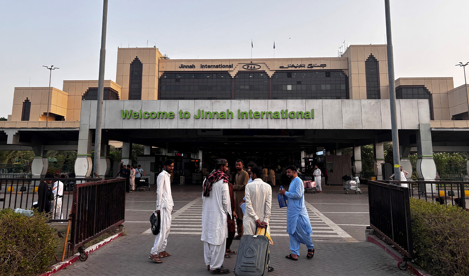 Passengers wait outside at Jinnah International airport after all domestic and international flights were cancelled in Karachi on May 7, 2025. (AFP/File)