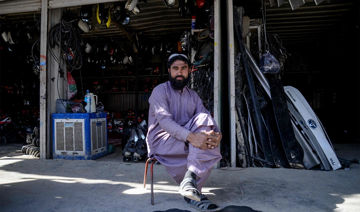 This photograph taken on December 29, 2025 shows a man sitting outside an auto parts shop at a market near the zero-point border crossing between Afghanistan and Pakistan in the Spin Boldak district of Kandahar province. (AFP)