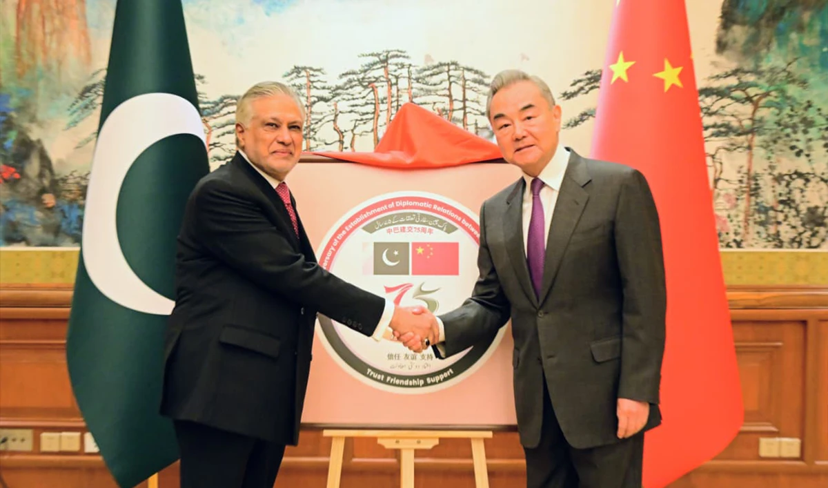 Pakistani Foreign Minister Ishaq Dar shakes hands with his Chinese counterpart Wang Yi upon jointly unveiling the logo for the 75th anniversary of Pakistan-China diplomatic relations, in Beijing on January 3, 2026. (@ForeignOfficePk/X)