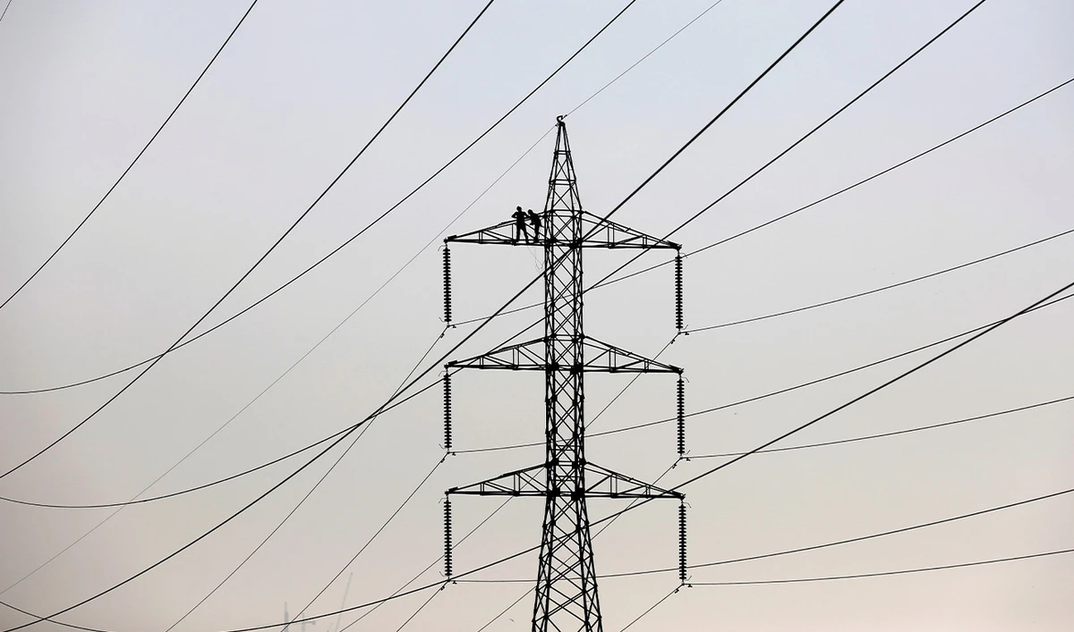 Technicians work to clean power transmission tower in Karachi, Pakistan, December 7, 2018. (Reuters/File)
