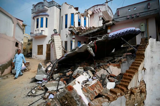 A Pakistani earthquake survivor walks past a collapsed house in an earthquake-hit area on the outskirts of Mirpur in Pakistan-controlled Kashmir on September 25, 2019. (AFP/ file)