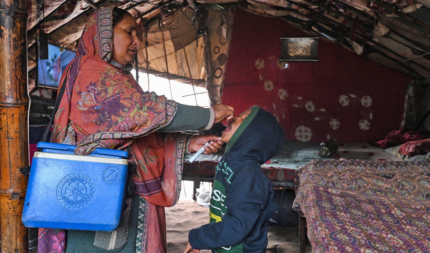 A health worker administers polio drops to a child for vaccination during a door-to-door poliovirus eradication campaign in Lahore on December 15, 2025. (AFP/File)