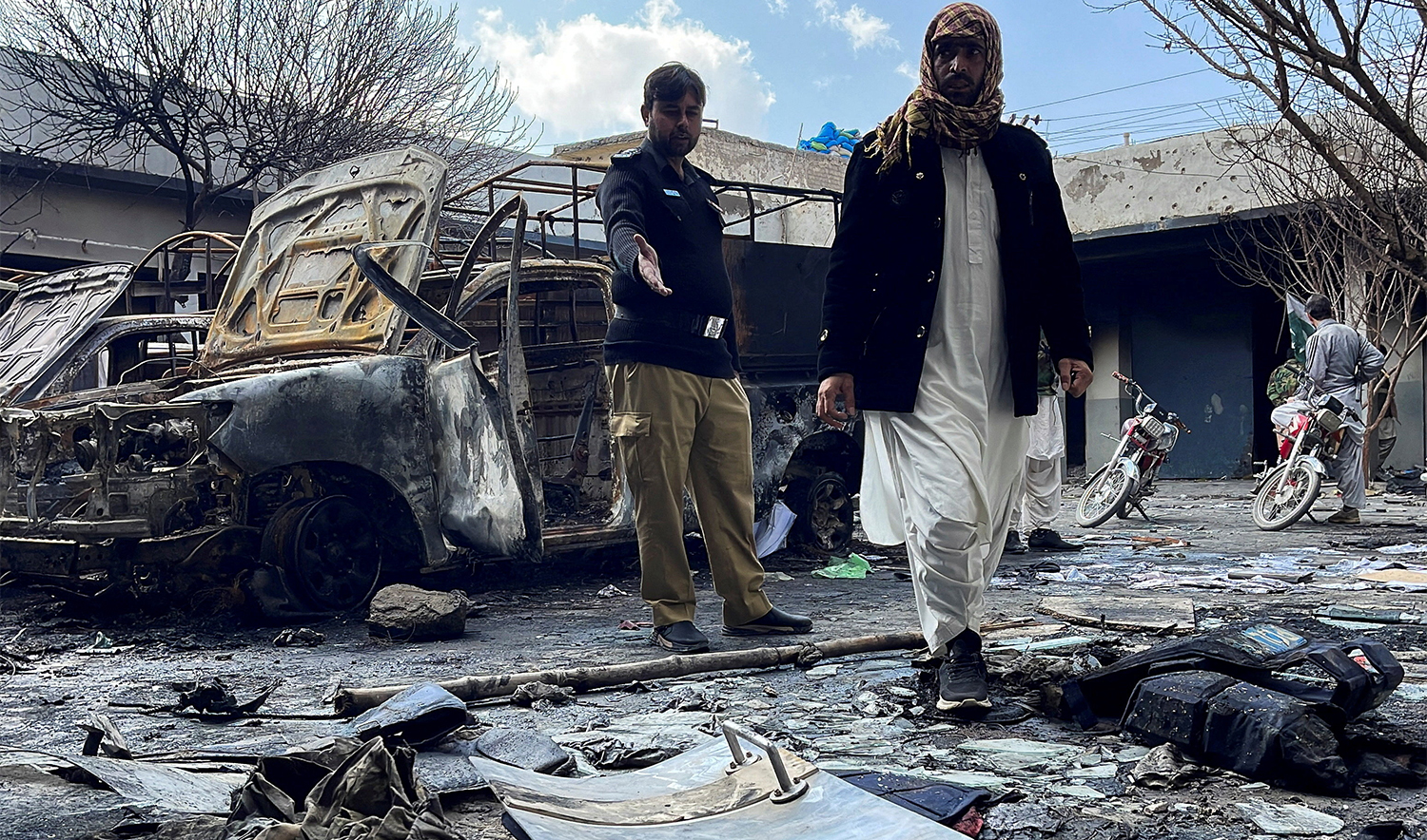 A police officer and a person stand amid damages at a police station, following militant attacks, in Quetta, Pakistan, on February 1, 2026. (REUTERS)