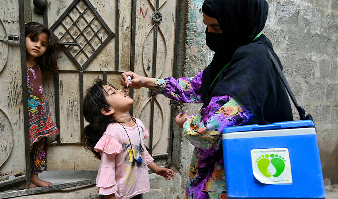 A health worker administers polio drops to a child for vaccination on the first day of a nationwide week-long poliovirus eradication campaign in Karachi on May 26, 2025. (AFP/File)