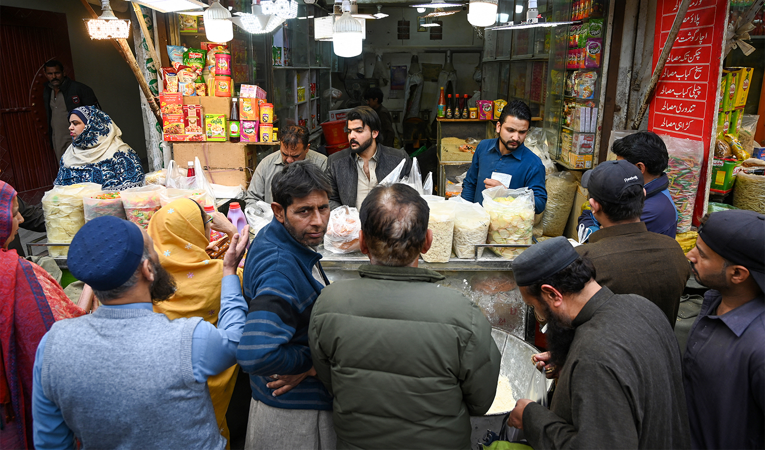 People buy grocery at a shop ahead of the Islamic holy fasting month of Ramadan in Rawalpindi on March 11, 2024. (AFP/File)