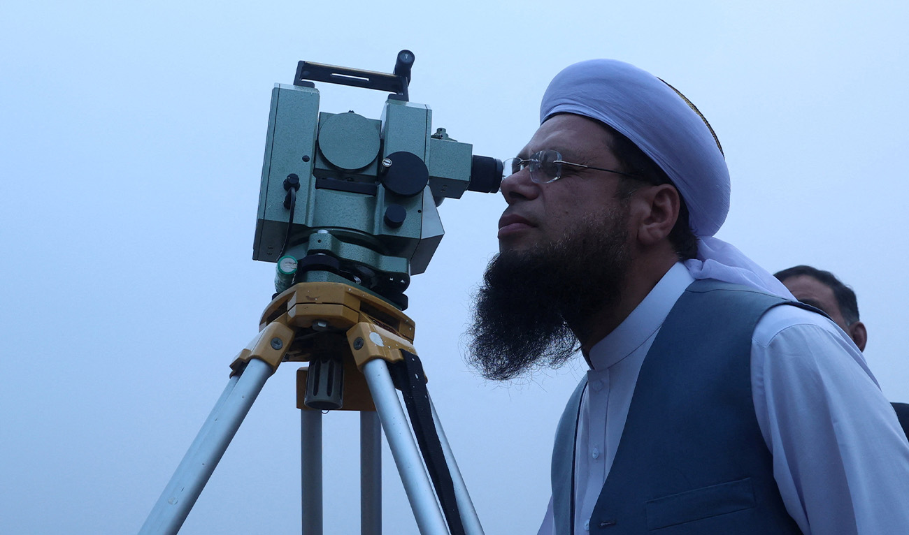 A member of Central Ruet-e-Hilal Committee, Pakistan's moon sighting committee, uses a theodolite to look for the new moon that will mark the start of the holy fasting month of Ramadan, in Peshawar, Pakistan, February 28, 2025. (Reuters/File)