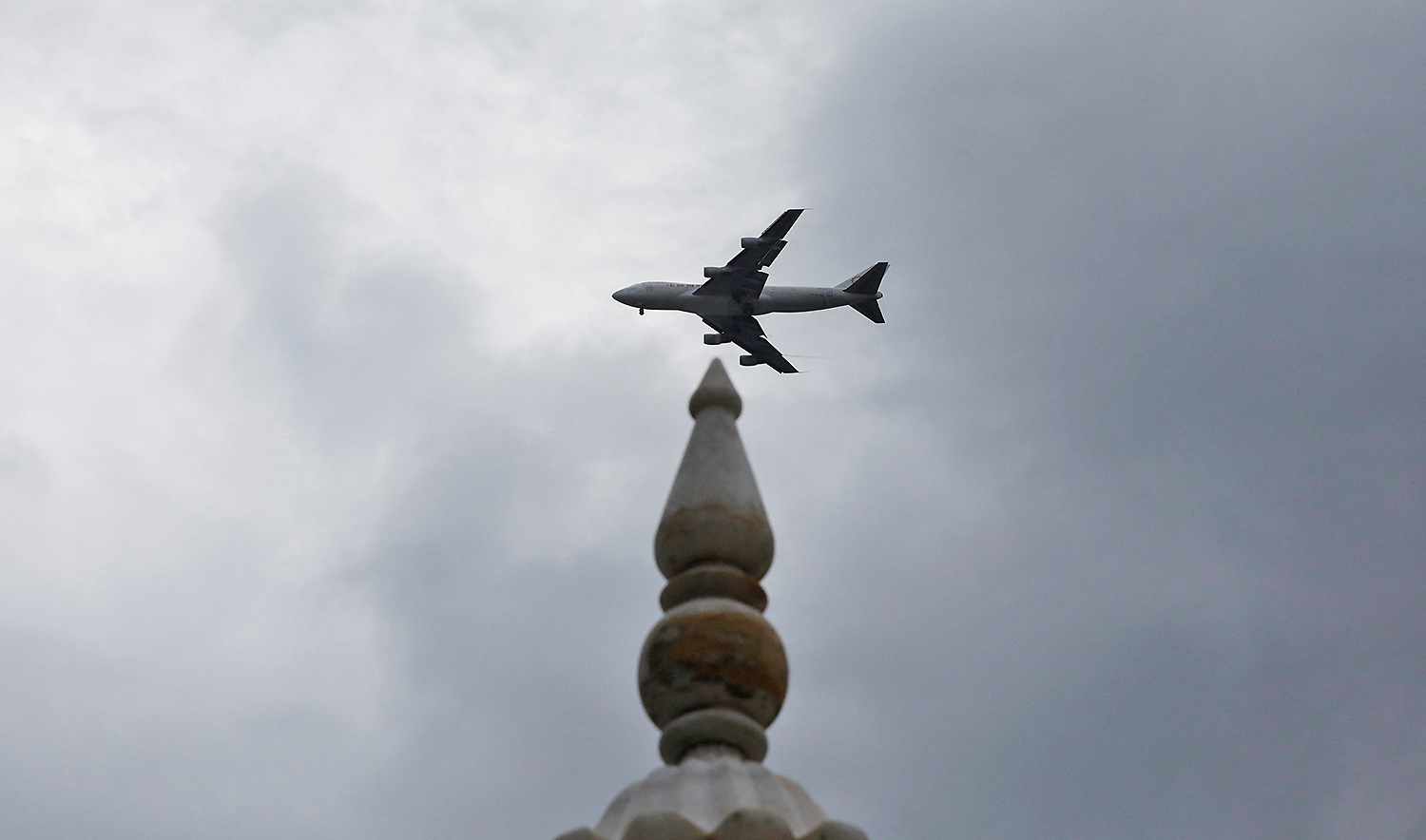 A plane flies past a monumemt in Karachi, Pakistan on July 17, 2022. (REUTERS/File)