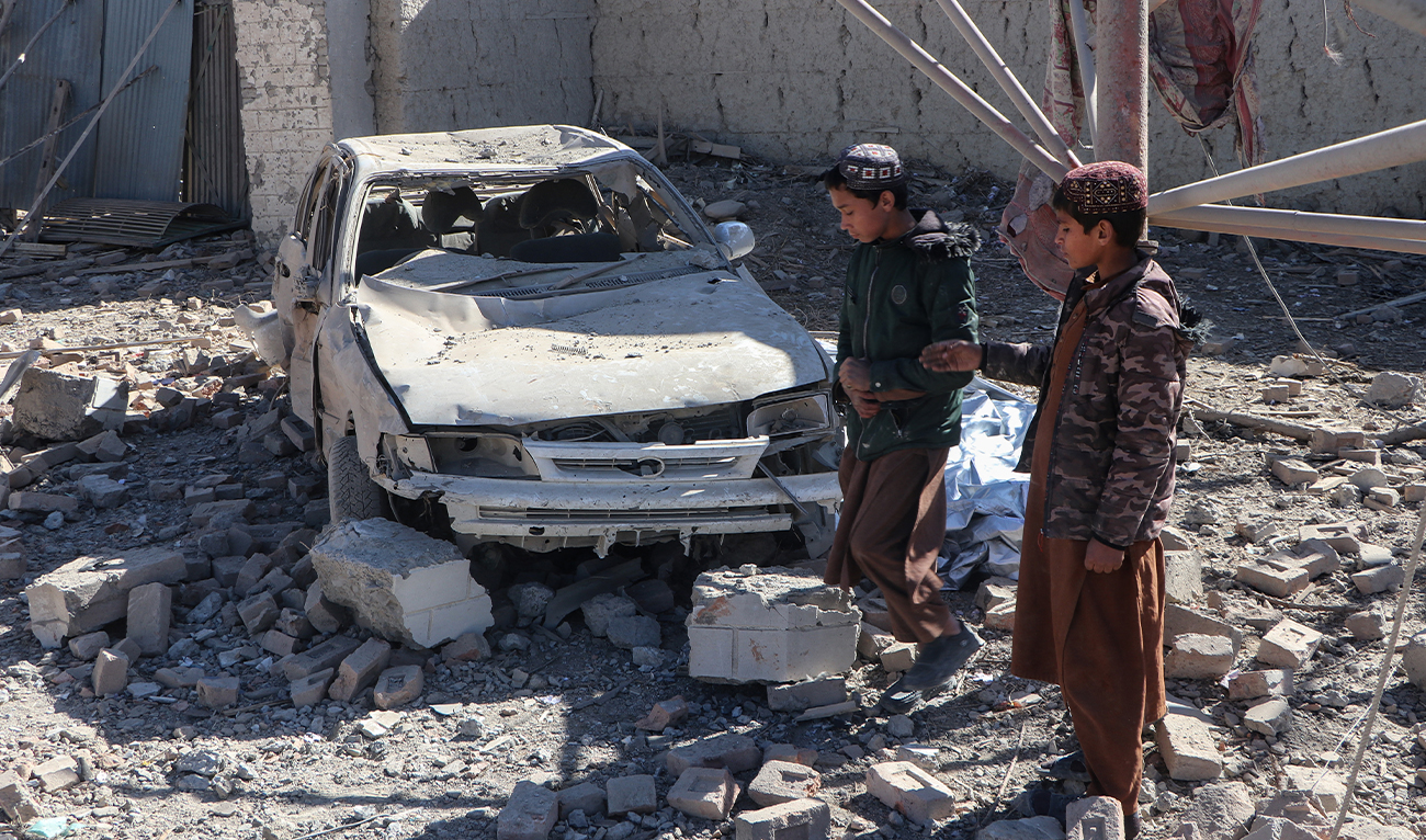 Afghan children walk past a damaged car after an overnight Pakistani airstrike at the Balish village in Urgun district, Paktika Province, Afghanistan, on February 22, 2026. (AFP/File)