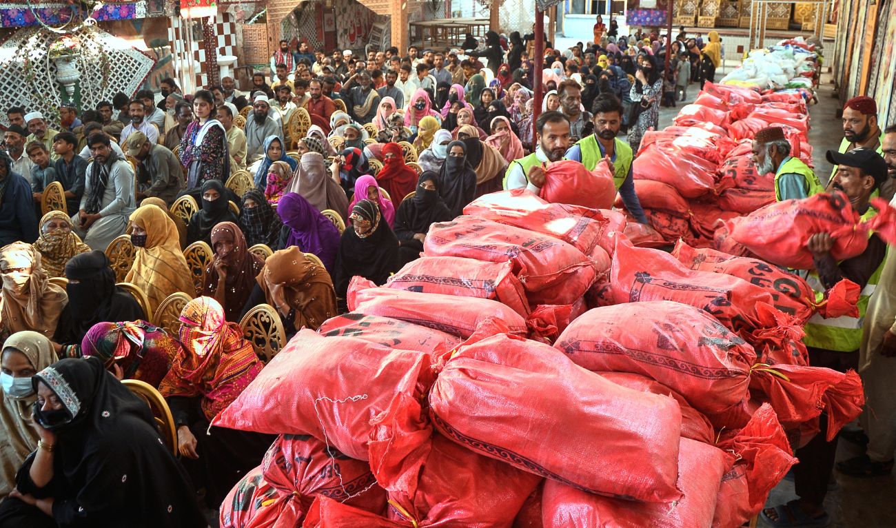 People wait for their turn to get free sack of relief aid distributed by a charity group for the Muslim's holy fasting month of Ramadan, in Hyderabad, Pakistan, Wednesday, Feb. 25, 2026. (AP)