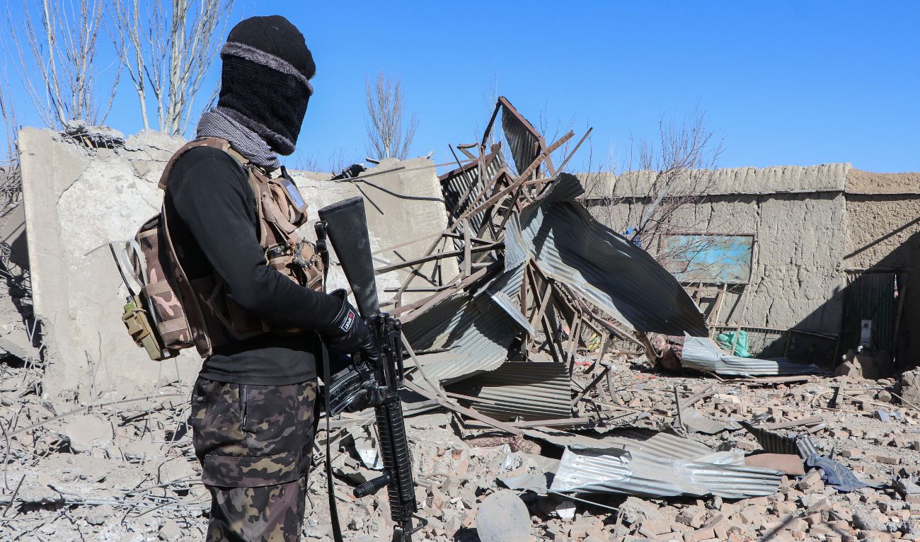 A Taliban security personnel stands next to the debris of houses destroyed during an overnight Pakistani airstrike at the Balish village in Urgun district, Paktika Province, on February 22, 2026. (AFP/ file)