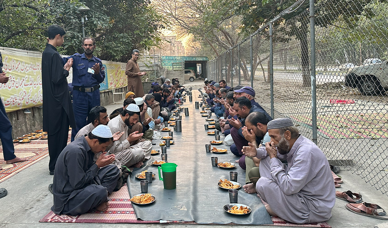 People sit together and raise their hands in prayer before breaking their fast at iftar during the holy month of Ramadan in Islamabad, Pakistan, February 25, 2026.