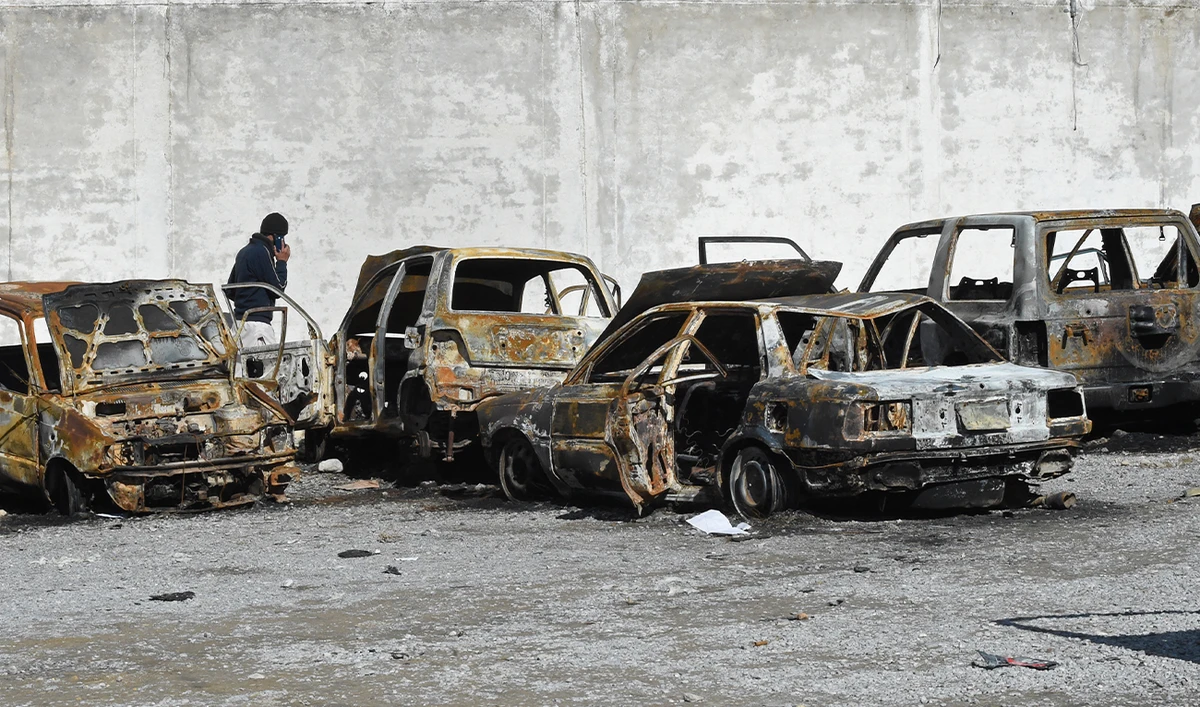A man walks past burnt vehicles in a torched police station on the outskirts of Quetta on February 1, 2026 a day after an attack by Baloch separatists. (AFP/File)