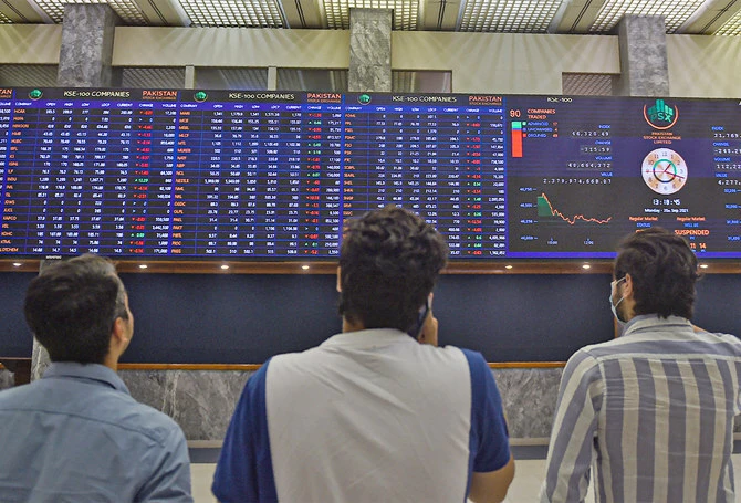 Stockbrokers watch an index board showing the latest share prices during a trading session at the Pakistan Stock Exchange (PSX) in Karachi, Pakistan, on September 20, 2021. (AFP/File)