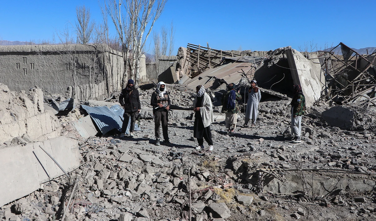 Taliban security personnel stand next to the debris of houses destroyed during an overnight Pakistani airstrike at the Balish village in Urgun district, Paktika Province, on February 22, 2026. (AFP)