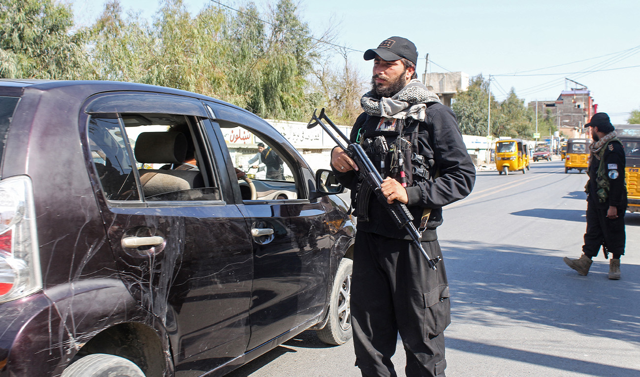 Taliban security personnel stand guard as vehicles ride past a checkpoint in Jalalabad on March 2, 2026 amid Afghanistan-Pakistan cross-border clashes. (AFP/File)