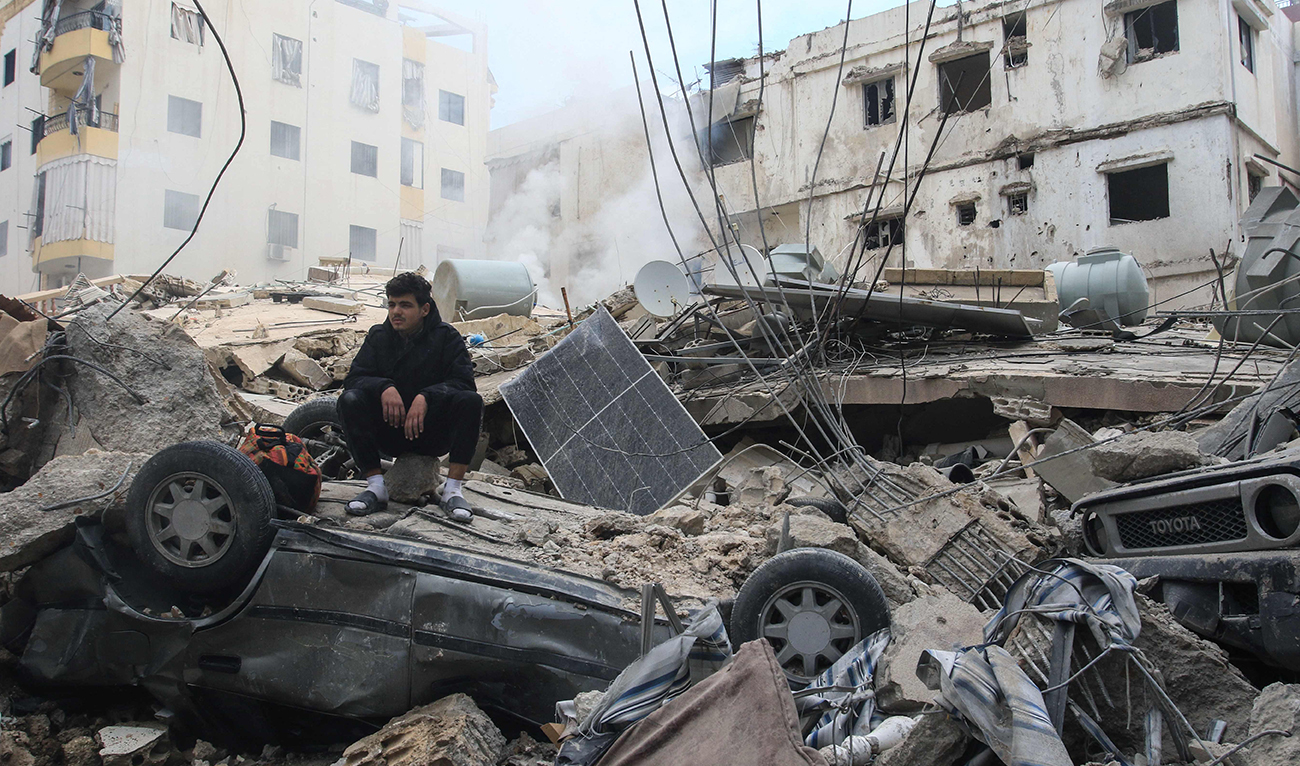 A man sits on the rubble of a building that was targeted by an Israeli airstrike the previous day in the southern Lebanese coastal city of Sidon on March 4, 2026. (AFP)