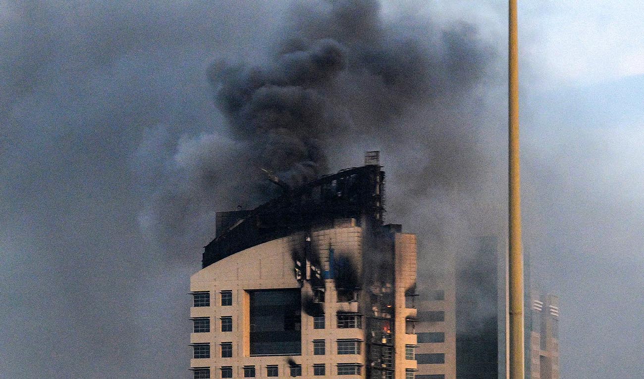 Smoke rises from a high-rise building following a drone attack in Kuwait City on March 8, 2026. (AFP)