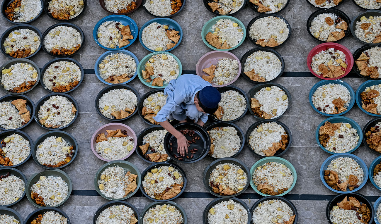 A volunteer arranges iftar meals for Muslim devotees during the Islamic holy fasting month of Ramadan in Karachi on February 27, 2026. (AFP/File)