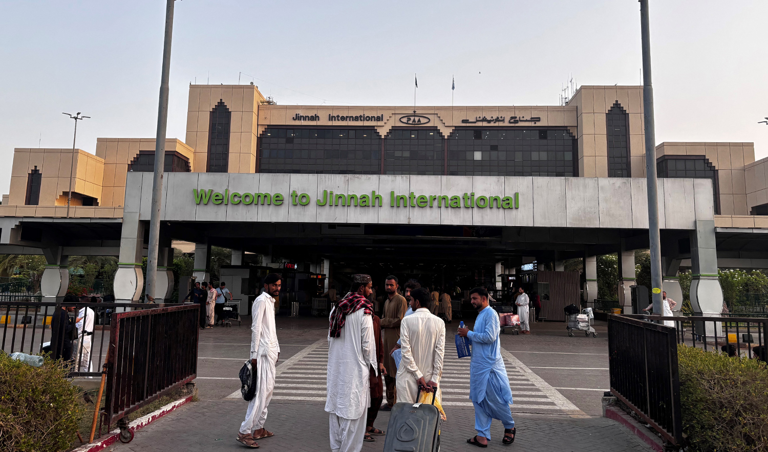 Passengers wait outside at Jinnah International airport after all domestic and international flights were cancelled in Karachi on May 7, 2025. (AFP/File)