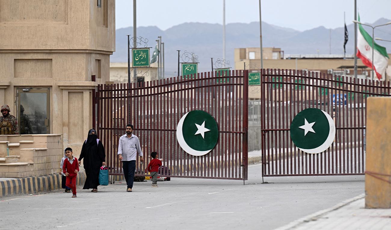 Pakistanis walk across the Taftan border as they return from Iran, in Balochistan province, on March 9, 2026 amid ongoing US-Israel strikes on Iran. (AFP)