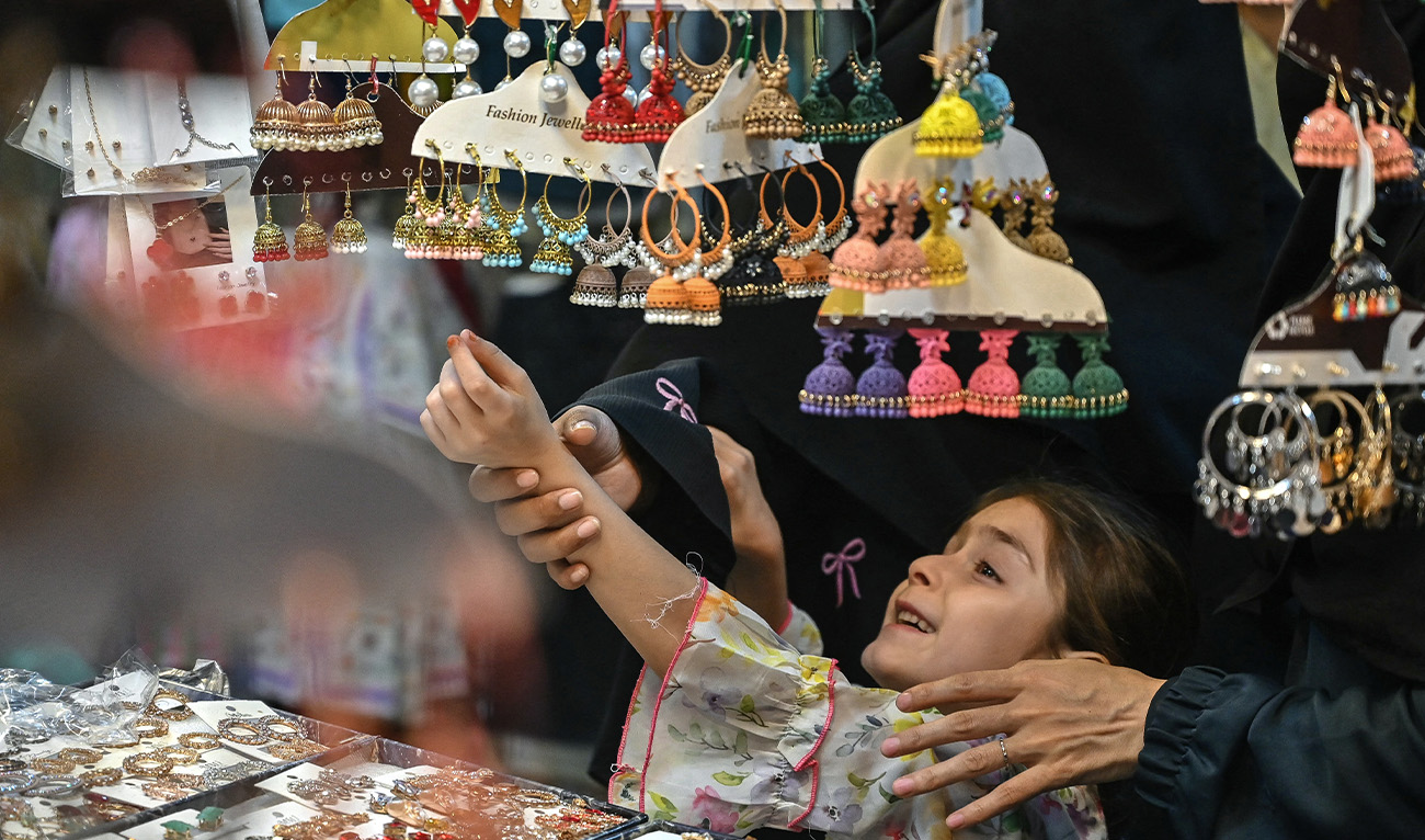 A Muslim girl shops for jewellery ahead of the Eid al-Fitr celebrations during the last week of the Islamic holy fasting month of Ramadan in Karachi on March 15, 2026. (AFP/File)
