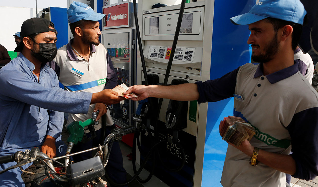 Malik Mohsin Ali, a rider for Bykea, ride-hailing and delivery platform, pays for fuel at a petrol station in Karachi, Pakistan, March 18, 2026. (AFP/File)