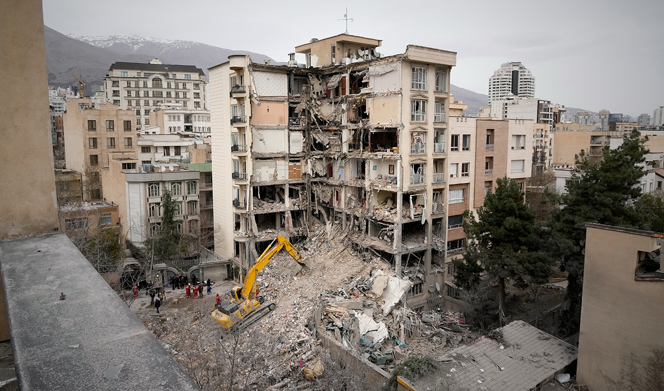 Iranian Red Crescent emergency workers use a bulldozer to clear rubble from a residential building that was hit in an earlier US-Israeli strike in Tehran, Iran, on March 23, 2026. (AP)