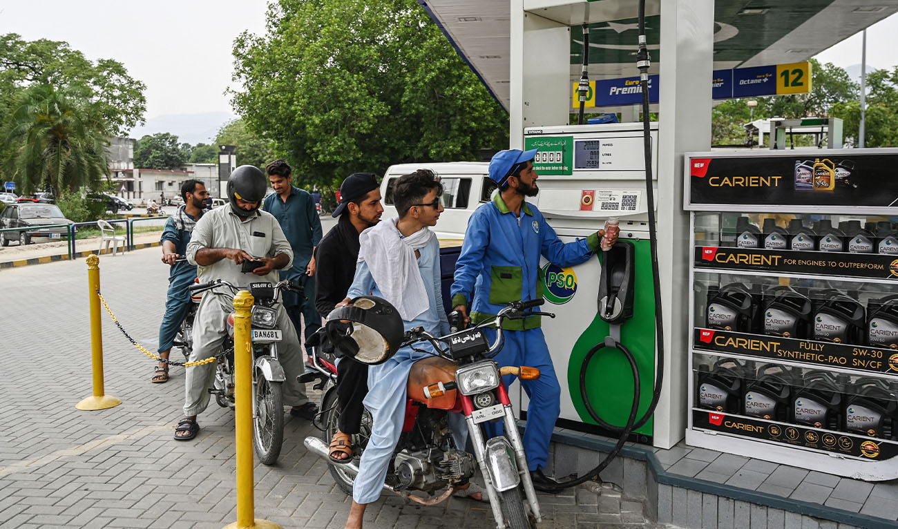 An employee fills the tank of a motorbike at a fuel station in Islamabad on June 16, 2025, after a hike in prices of petroleum products by the government. (AFP/File)