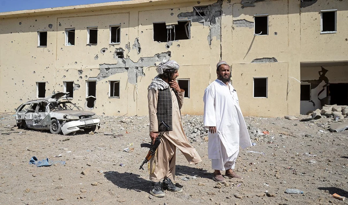 Taliban security personnel stand at the site of a Pakistani air strike near a refugee registration center in the Takhta Pul district of Kandahar on February 28, 2026. (AFP)